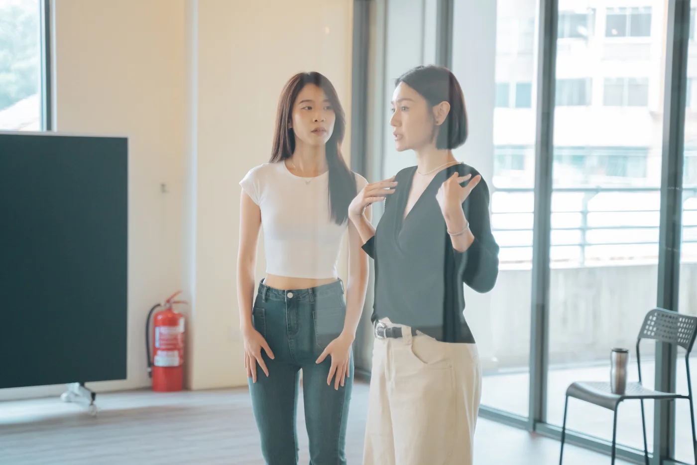 One-to-one coaching: a coach gestures as she talks a student through her posture