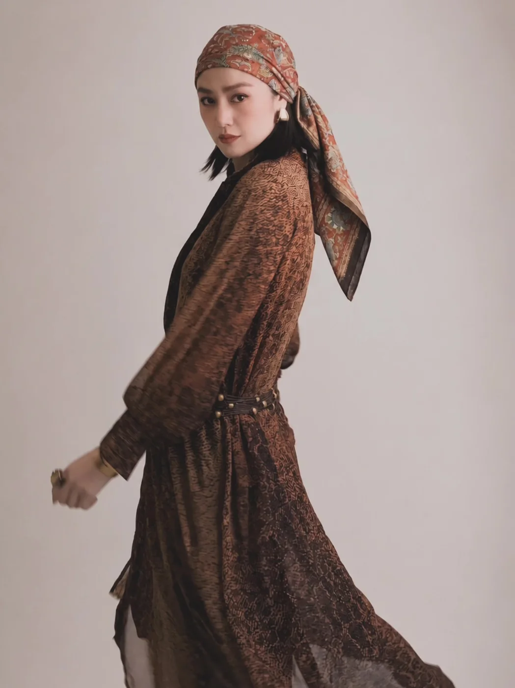 Editorial shoot: the same headscarf and patterned dress, the model turning mid-step